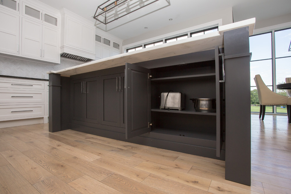 Inspiration for a mid-sized transitional u-shaped light wood floor and brown floor eat-in kitchen remodel in Baltimore with an undermount sink, shaker cabinets, blue cabinets, marble countertops, gray backsplash, marble backsplash, stainless steel appliances and an island