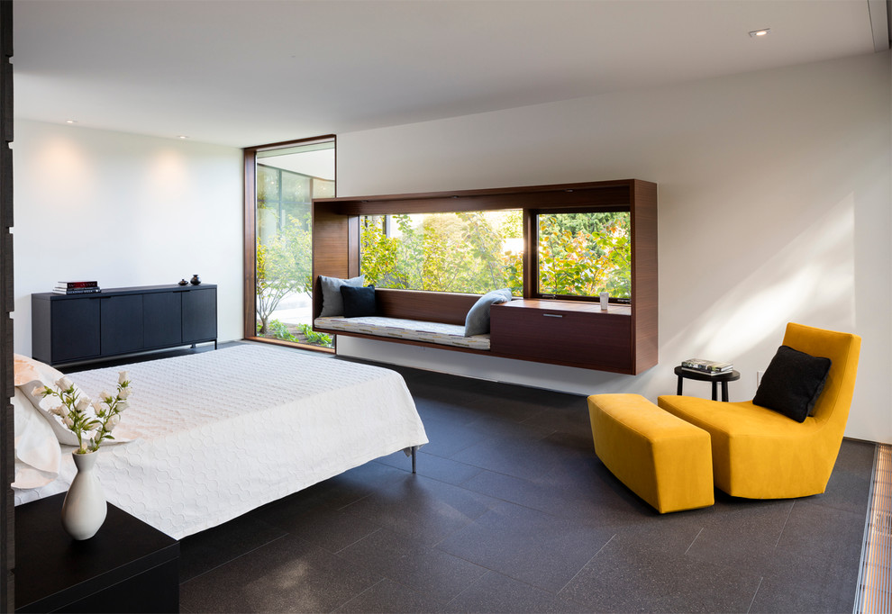 This is an example of a contemporary master bedroom in Seattle with white walls and porcelain floors.