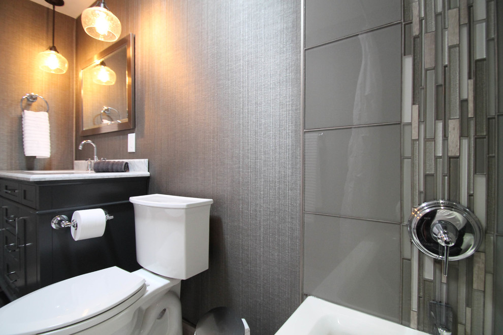 Alcove bathtub - mid-sized transitional gray tile and glass tile porcelain tile alcove bathtub idea in Denver with shaker cabinets, gray cabinets, a one-piece toilet, gray walls, an undermount sink and marble countertops