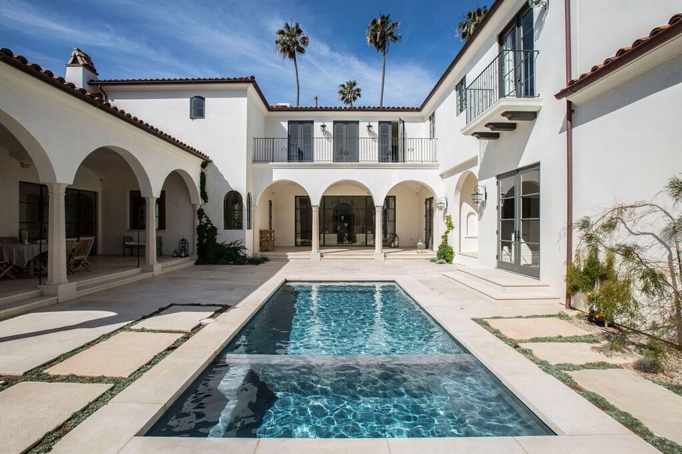 Photo of a mid-sized mediterranean courtyard rectangular pool in San Diego with a water feature and concrete slab.
