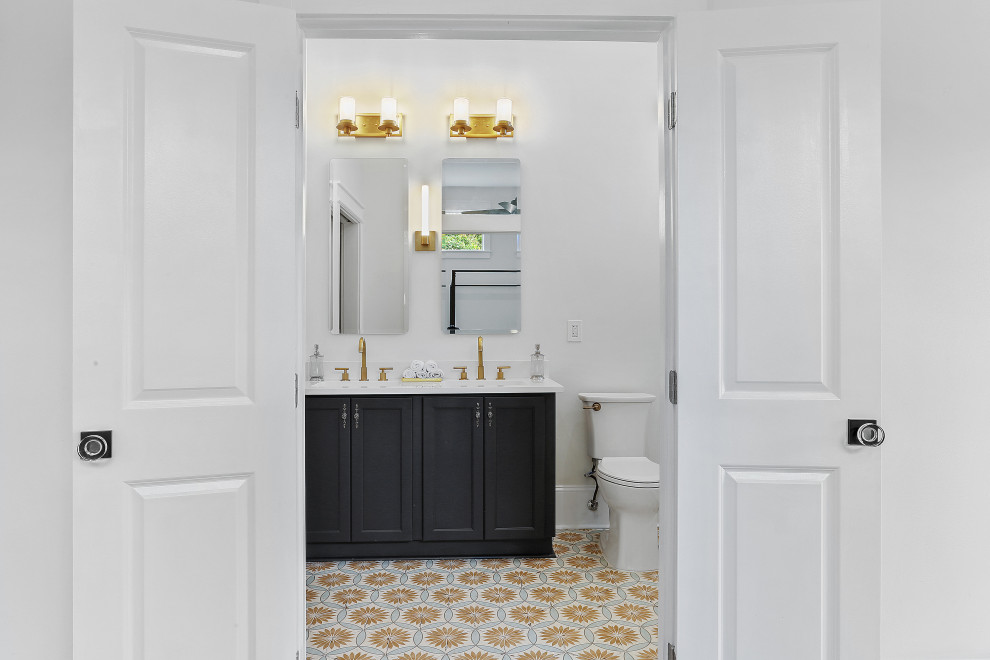 Idéer för att renovera ett stort amerikanskt vit vitt en-suite badrum, med luckor med infälld panel, blå skåp, ett badkar i en alkov, en dusch/badkar-kombination, en toalettstol med separat cisternkåpa, vit kakel, keramikplattor, vita väggar, cementgolv, ett undermonterad handfat, marmorbänkskiva och med dusch som är öppen