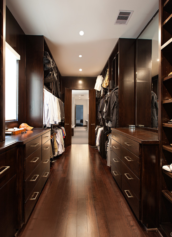 Large contemporary men's walk-in wardrobe in Houston with flat-panel cabinets, dark wood cabinets, dark hardwood floors and brown floor.