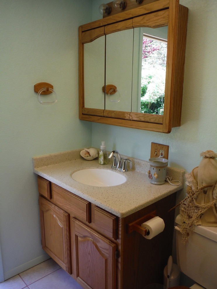 Beach style 3/4 bathroom photo with an integrated sink, raised-panel cabinets and solid surface countertops
