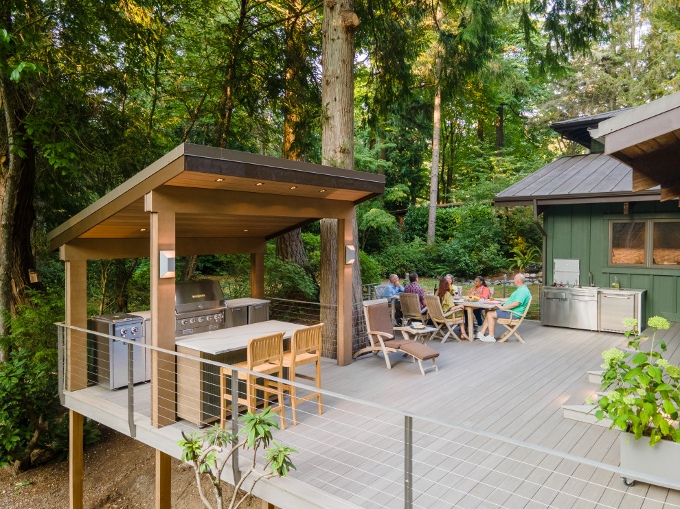 Inspiration for a large contemporary backyard ground level metal railing outdoor kitchen deck remodel in Seattle with a pergola