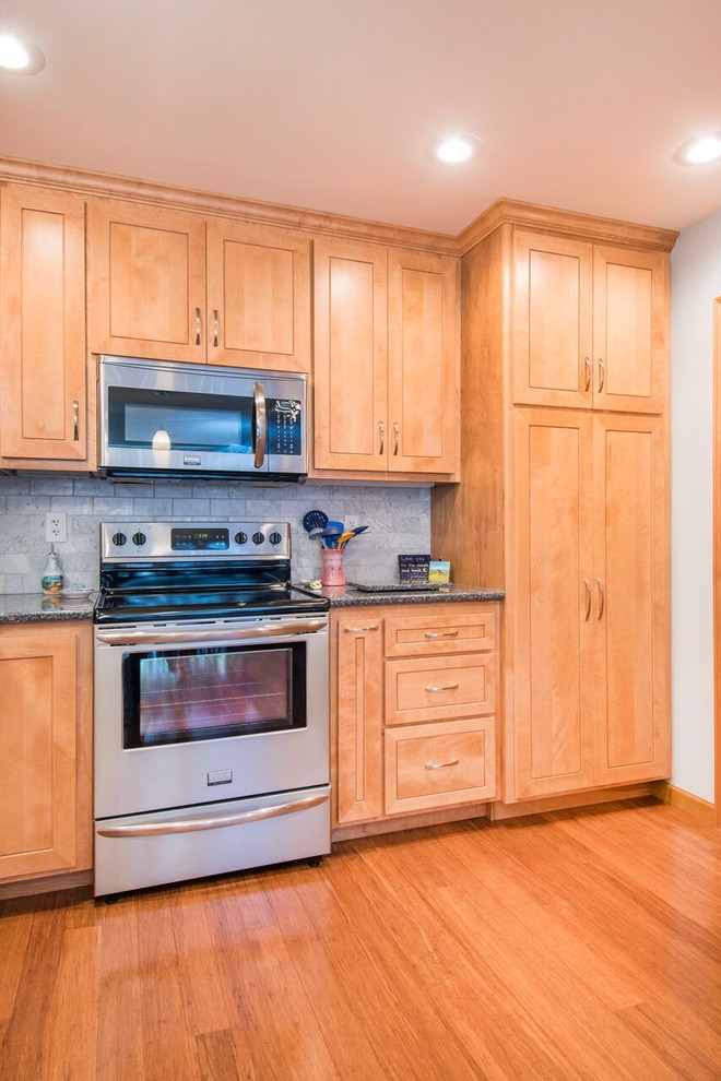 Inspiration for a mid-sized transitional u-shaped bamboo floor and brown floor enclosed kitchen remodel in Cincinnati with a double-bowl sink, shaker cabinets, light wood cabinets, granite countertops, gray backsplash, marble backsplash, stainless steel appliances, a peninsula and gray countertops