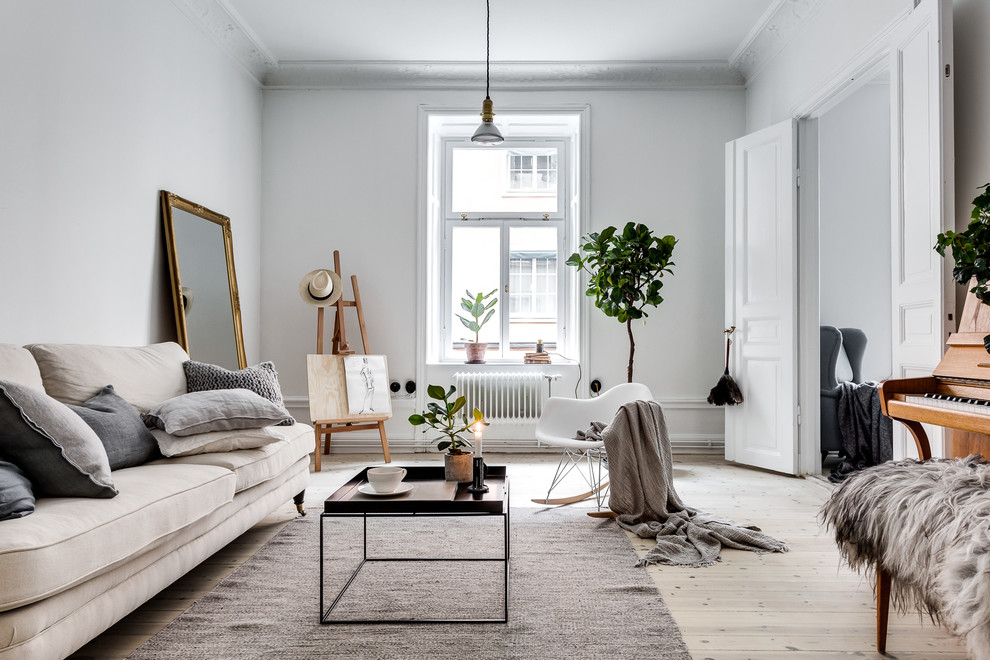 This is an example of a mid-sized scandinavian enclosed living room in Stockholm with a music area, white walls, light hardwood floors and no tv.