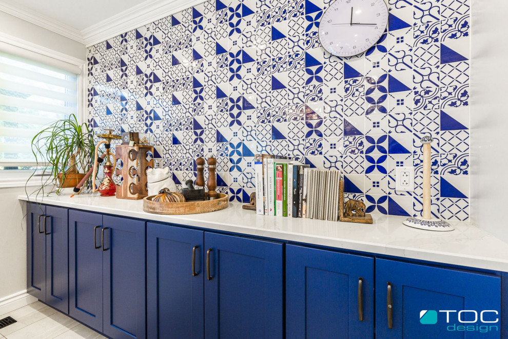 Inspiration for a mid-sized mediterranean galley separate kitchen in Other with an undermount sink, shaker cabinets, blue cabinets, quartz benchtops, blue splashback, ceramic splashback, white appliances, porcelain floors, with island, grey floor and white benchtop.