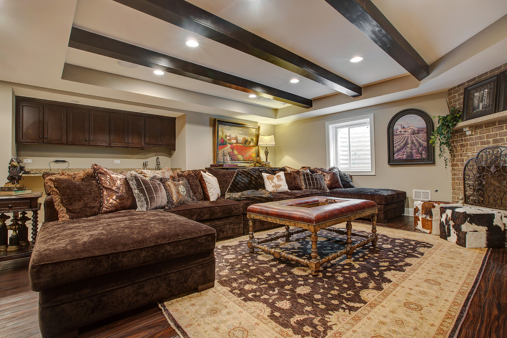 Design ideas for a large traditional basement in Chicago with beige walls, dark hardwood floors, a standard fireplace and a brick fireplace surround.