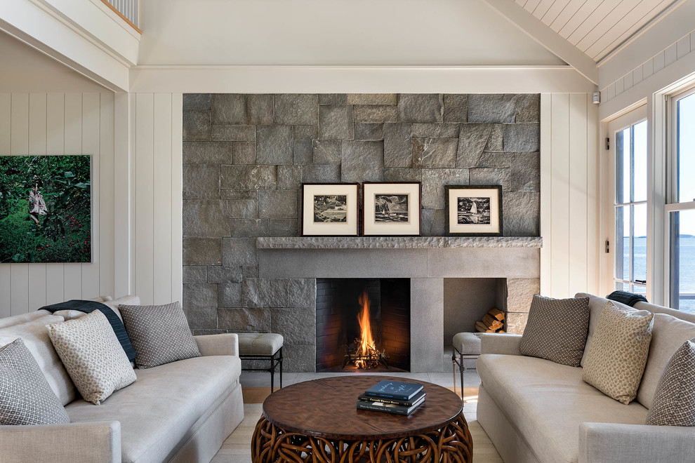 Photo of a large beach style formal open concept living room in Portland Maine with white walls, light hardwood floors, a standard fireplace and a concrete fireplace surround.
