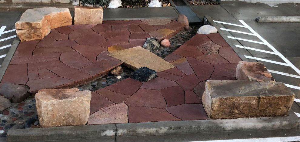 This is an example of a small contemporary courtyard full sun garden for winter in Other with with rock feature and natural stone pavers.