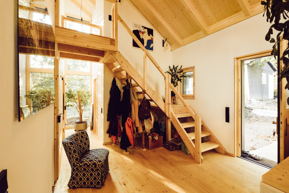 На фото: маленький, двухэтажный, деревянный частный загородный дом в стиле рустика с крышей-бабочкой, черепичной крышей и отделкой планкеном для на участке и в саду