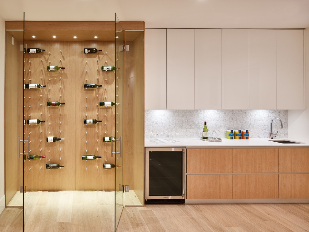 Inspiration for a mid-sized modern wine cellar in Vancouver with light hardwood floors, display racks and beige floor.