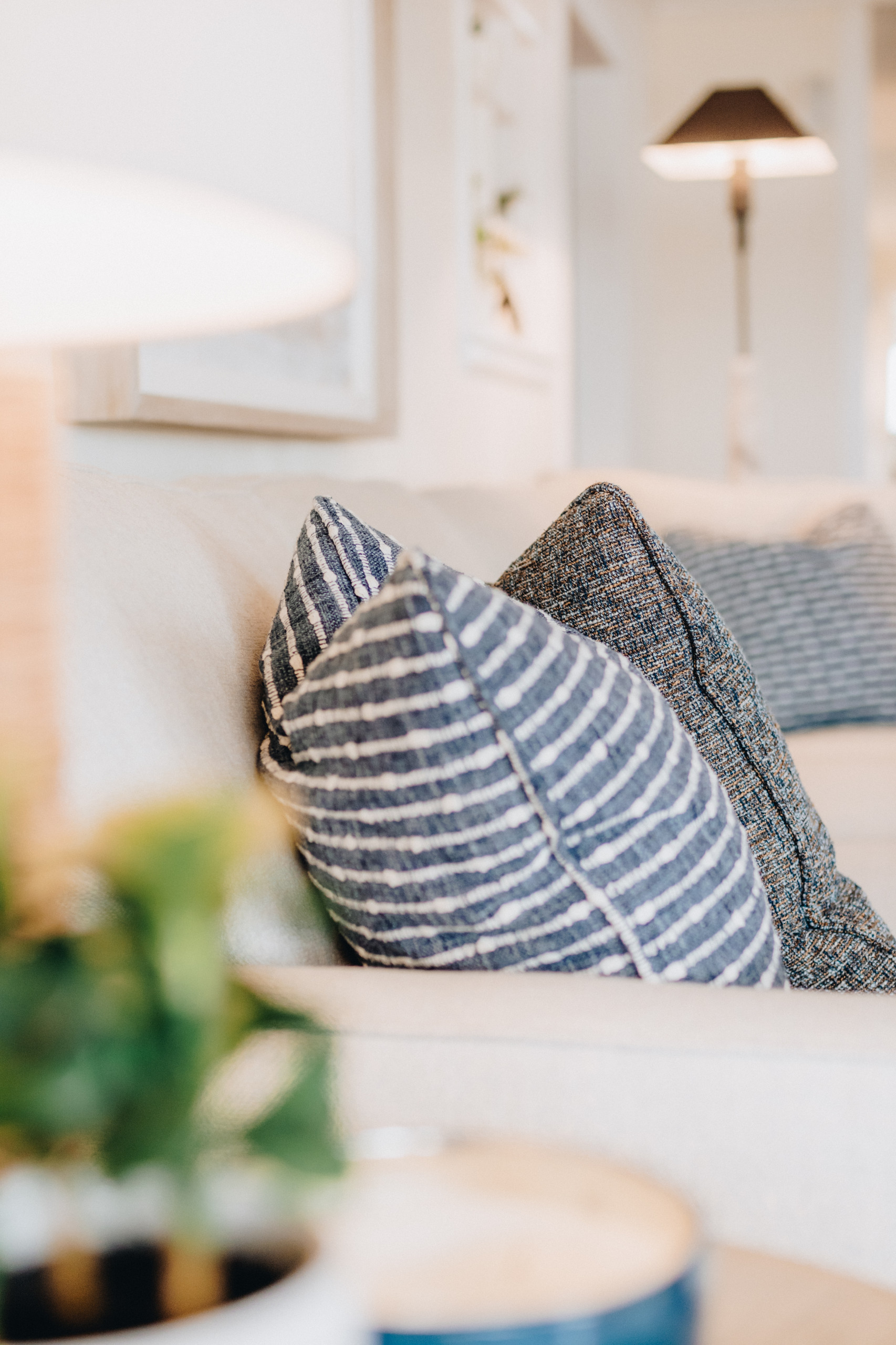 White couch with textured blue and white striped pillow