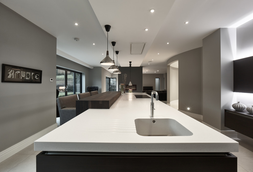 Design ideas for an expansive contemporary single-wall open plan kitchen in Other with flat-panel cabinets, solid surface benchtops, porcelain floors, with island, white cabinets, stainless steel appliances, grey floor and white benchtop.