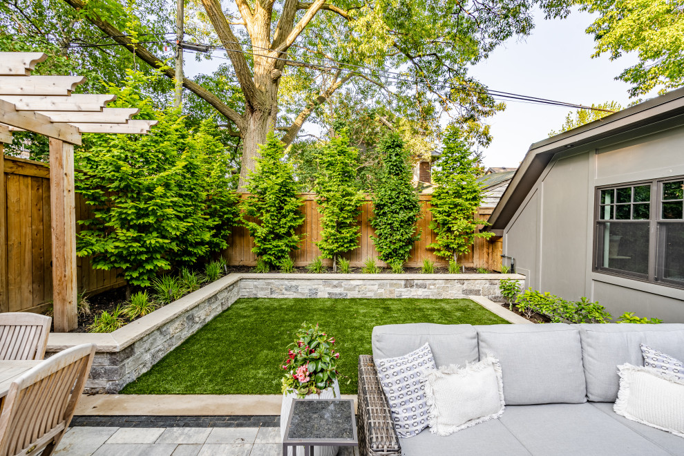 Mid-sized transitional front yard partial sun formal garden in Toronto with a garden path, concrete pavers and a metal fence for summer.