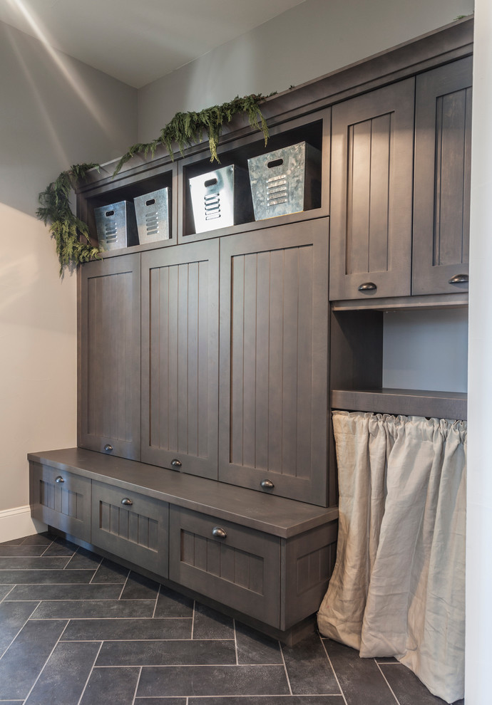 Example of a transitional porcelain tile entryway design in Denver with a farmhouse sink, raised-panel cabinets, white cabinets, soapstone countertops, white backsplash, subway tile backsplash, stainless steel appliances and an island