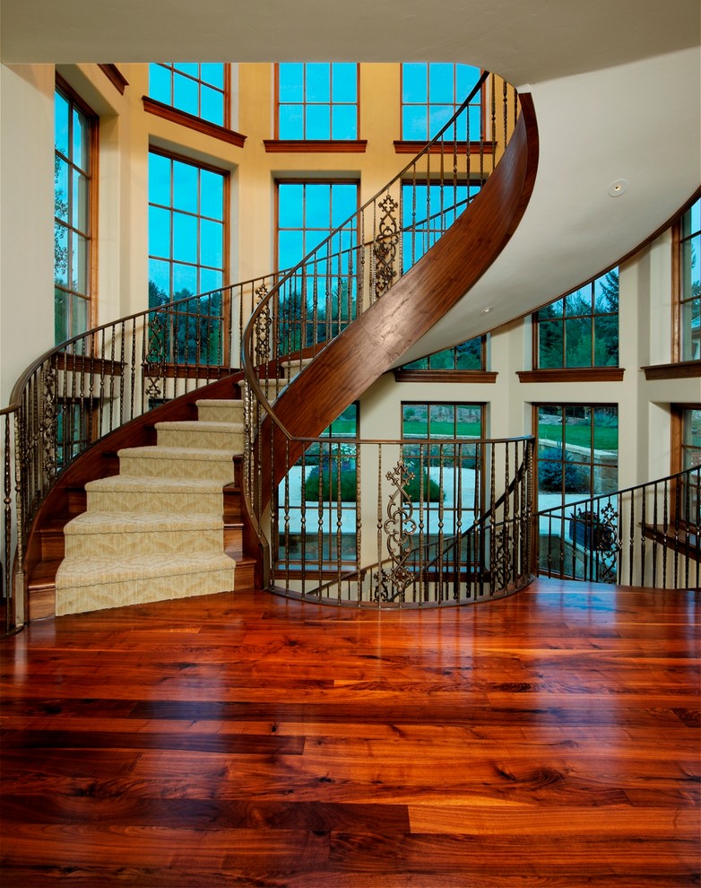 Design ideas for a traditional wood curved staircase in Denver with wood risers.