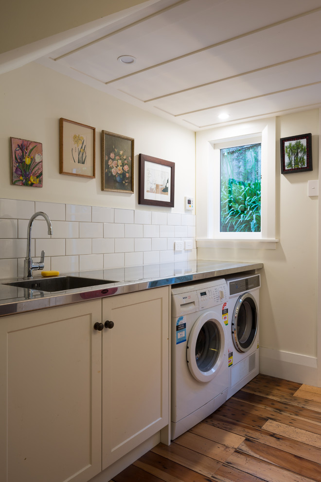 This is an example of a transitional laundry room in Auckland.