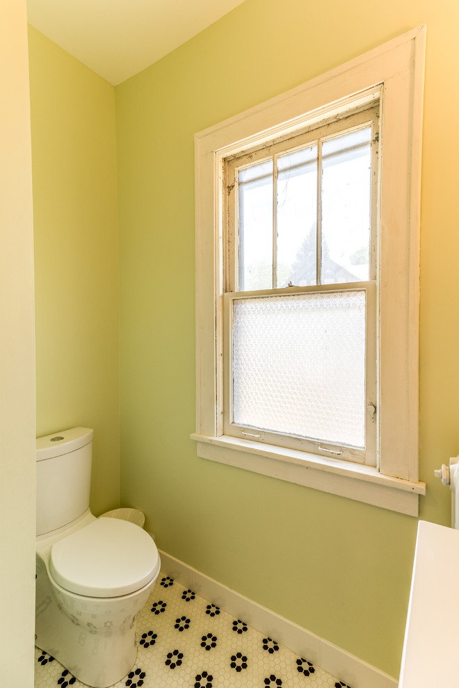 Photo of a mid-sized transitional kids bathroom in Minneapolis with recessed-panel cabinets, white cabinets, an alcove tub, an alcove shower, a one-piece toilet, green walls, porcelain floors, an integrated sink, marble benchtops, multi-coloured floor, a shower curtain and white benchtops.