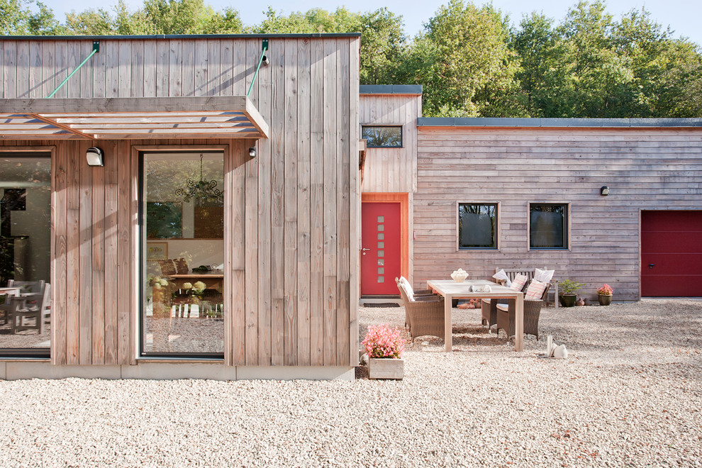 Inspiration for a mid-sized contemporary one-storey brown exterior in Lille with wood siding and a flat roof.