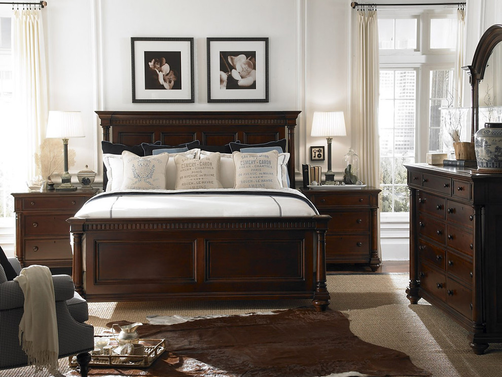 This is an example of a traditional bedroom in Charlotte with white walls.