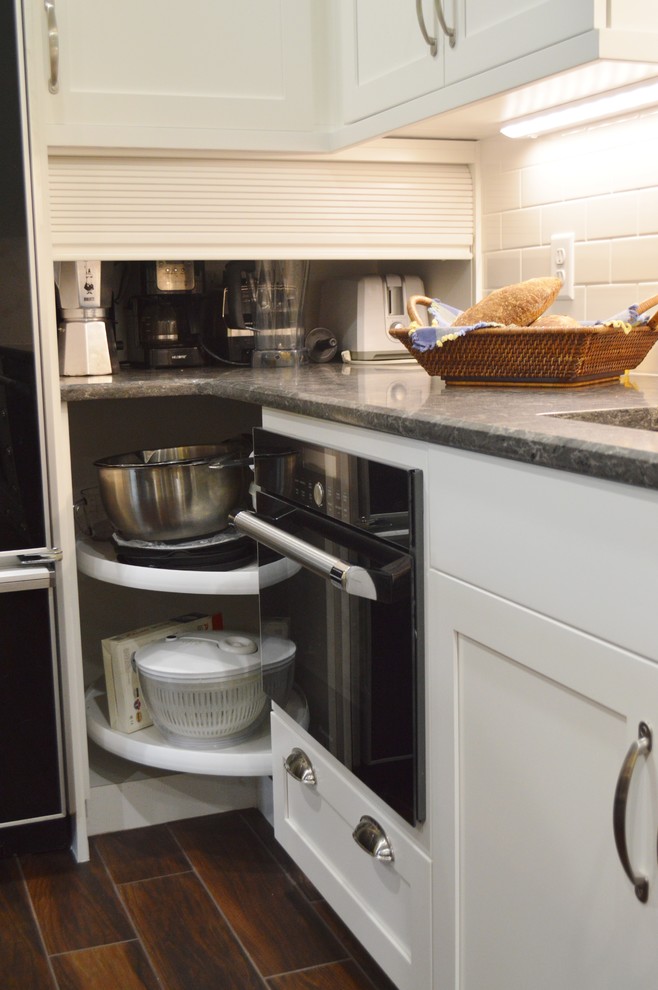 Kitchen - large dark wood floor kitchen idea with shaker cabinets, white cabinets, quartzite countertops, white backsplash, subway tile backsplash, stainless steel appliances and an island