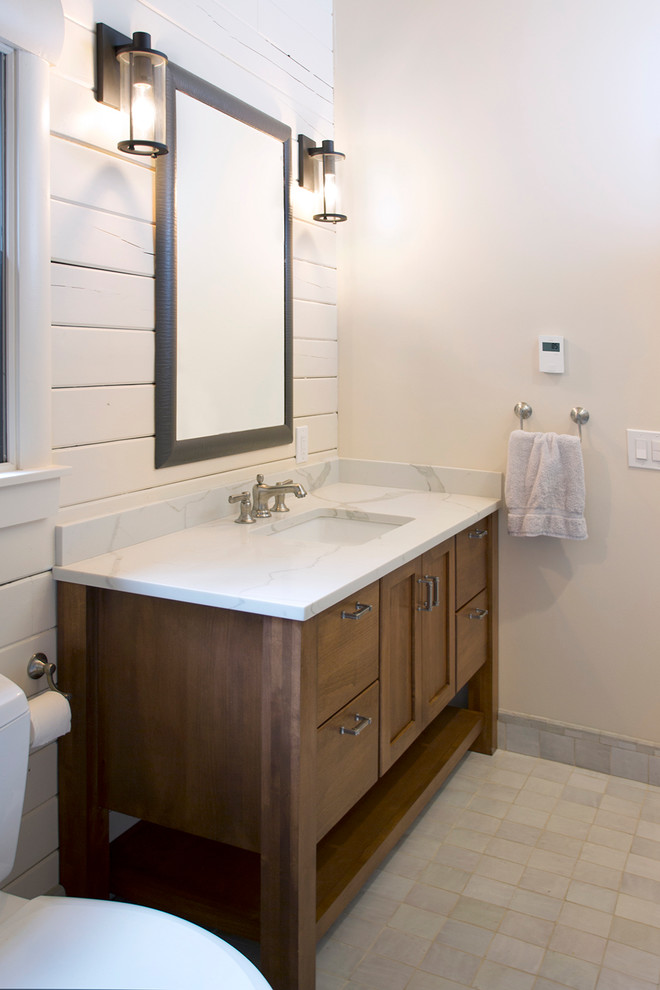 Photo of a large modern master bathroom in New York with shaker cabinets, dark wood cabinets, an alcove shower, a two-piece toilet, white tile, subway tile, white walls, porcelain floors, an undermount sink, engineered quartz benchtops, grey floor, a hinged shower door and white benchtops.