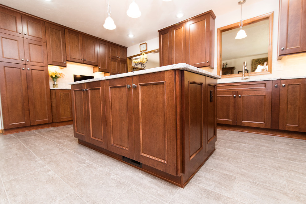 Inspiration for a large timeless l-shaped vinyl floor and beige floor eat-in kitchen remodel in Baltimore with an undermount sink, shaker cabinets, medium tone wood cabinets, granite countertops, beige backsplash, ceramic backsplash, stainless steel appliances, an island and white countertops