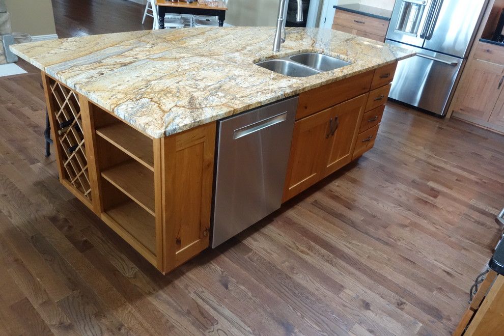 Mountain style l-shaped dark wood floor eat-in kitchen photo with an undermount sink, recessed-panel cabinets, medium tone wood cabinets, granite countertops, stainless steel appliances and an island