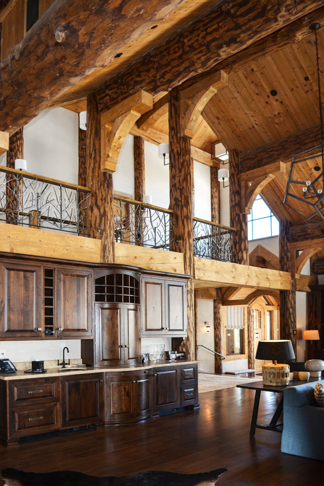 Inspiration for a rustic single-wall dark wood floor and brown floor open concept kitchen remodel in Denver with an undermount sink, raised-panel cabinets, dark wood cabinets and beige countertops