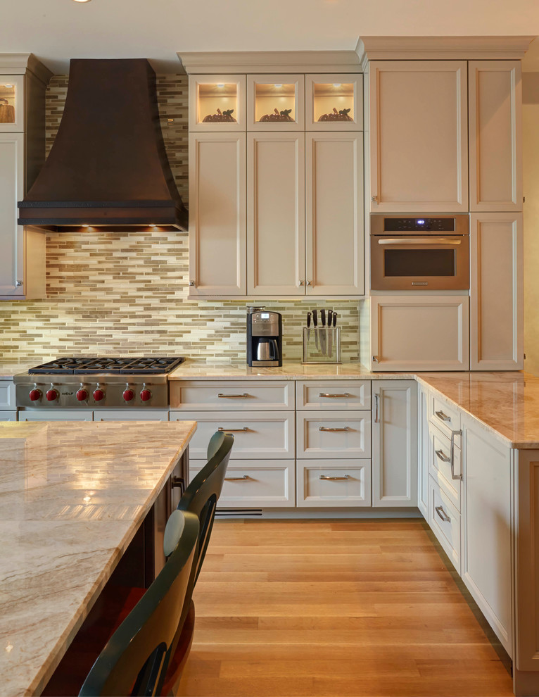 Design ideas for a transitional l-shaped kitchen in Chicago with recessed-panel cabinets, beige cabinets, multi-coloured splashback, medium hardwood floors and with island.