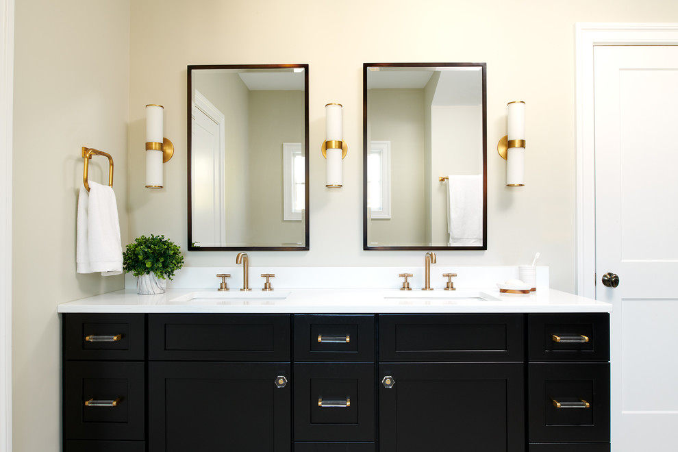 This is an example of a large transitional master bathroom in Philadelphia with shaker cabinets, black cabinets, a double shower, a bidet, black tile, porcelain tile, white walls, ceramic floors, an undermount sink, solid surface benchtops, white floor, a sliding shower screen and white benchtops.