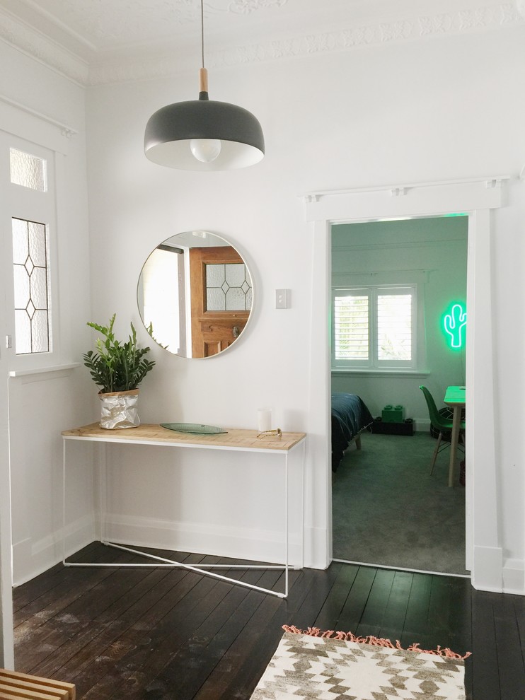 This is an example of a mid-sized scandinavian hallway in Sydney with white walls and dark hardwood floors.