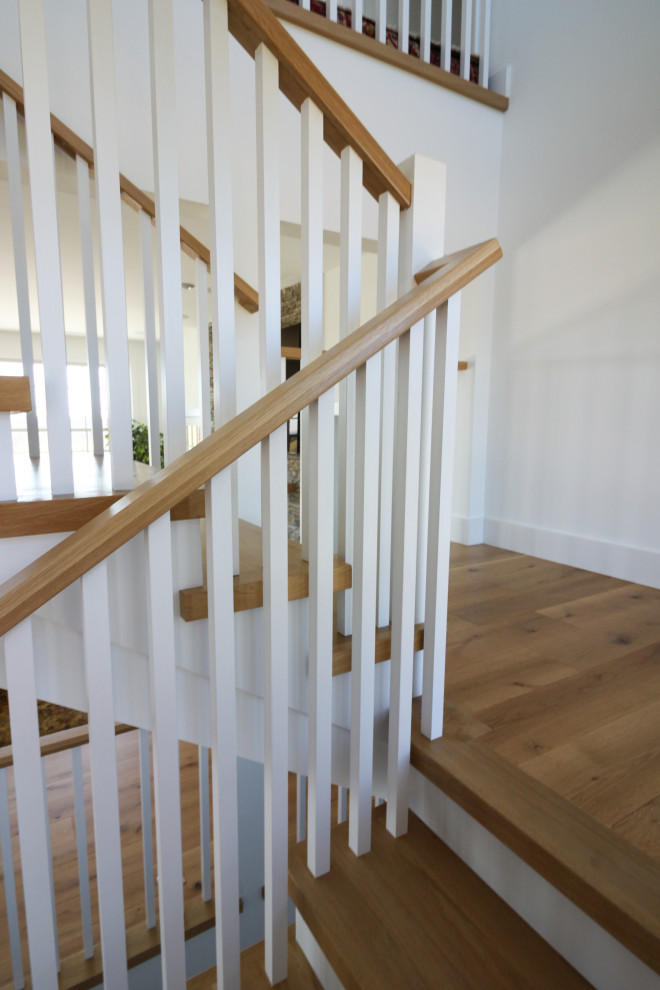 Aménagement d'un escalier campagne en U de taille moyenne avec des marches en bois, des contremarches en bois, un garde-corps en bois et du lambris de bois.