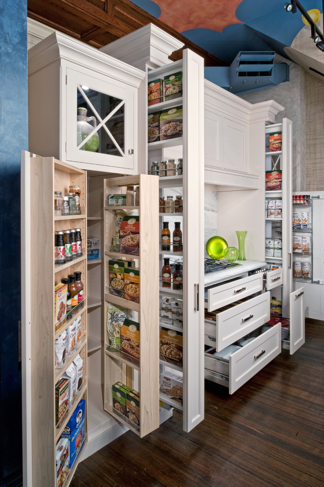 This is an example of a small traditional kitchen pantry in New York with recessed-panel cabinets, white cabinets, marble benchtops, a farmhouse sink, grey splashback, mosaic tile splashback, panelled appliances, dark hardwood floors and no island.