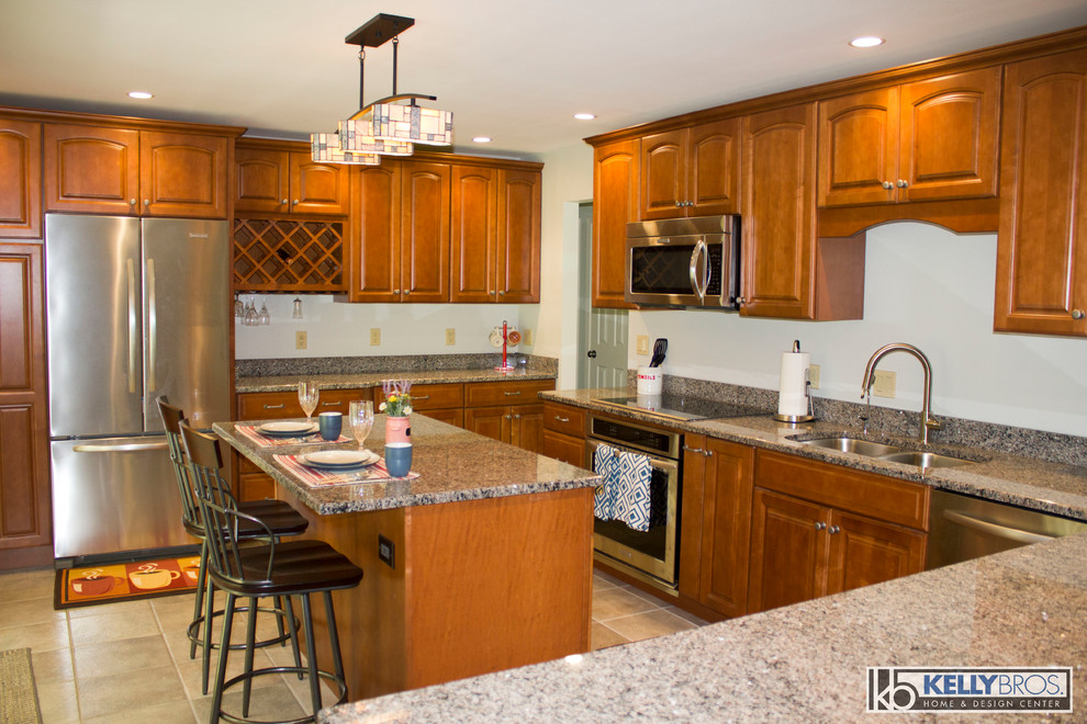 Large transitional u-shaped ceramic tile eat-in kitchen photo in Cincinnati with a double-bowl sink, raised-panel cabinets, medium tone wood cabinets, granite countertops, stainless steel appliances and an island