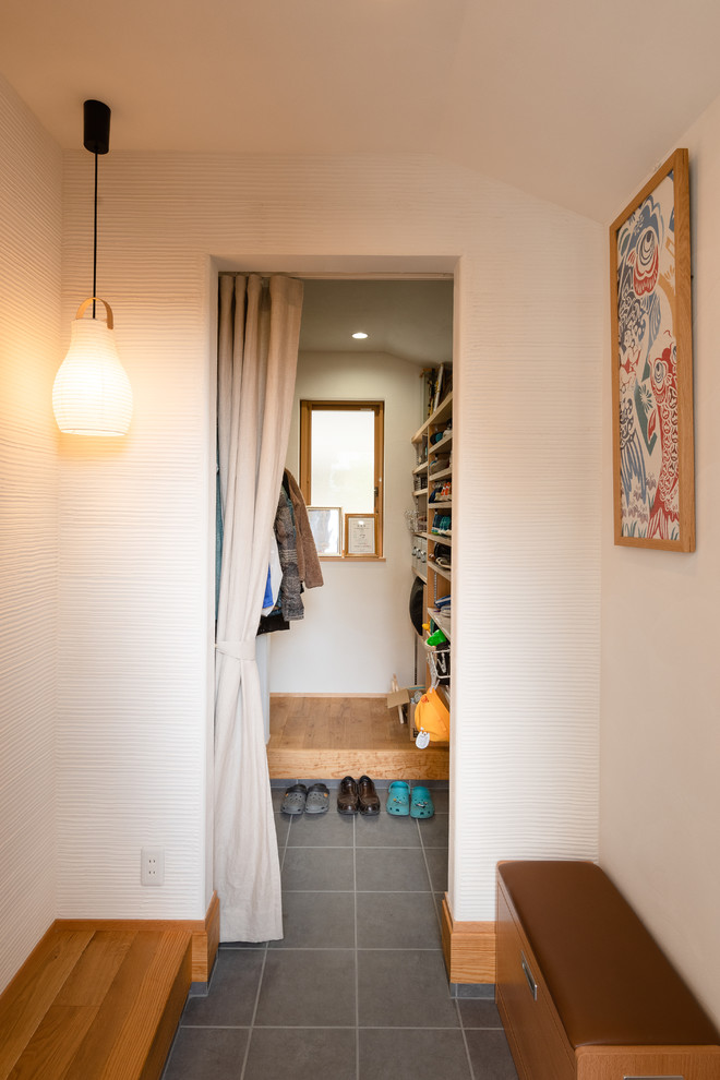 Photo of an asian entry hall in Nagoya with white walls, medium hardwood floors, a single front door and multi-coloured floor.