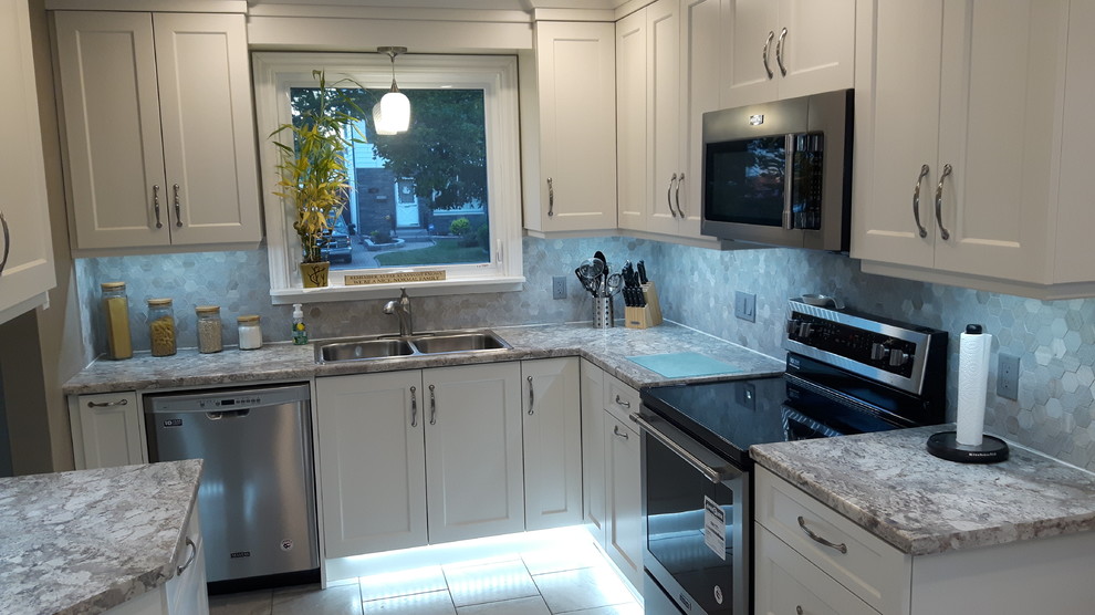 Enclosed kitchen - small transitional l-shaped porcelain tile and white floor enclosed kitchen idea in Toronto with an undermount sink, shaker cabinets, white cabinets, granite countertops, gray backsplash, porcelain backsplash, stainless steel appliances, no island and gray countertops