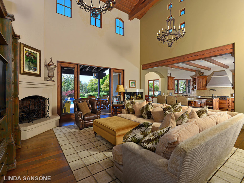 Mid-sized mediterranean open concept family room in San Diego with a concealed tv.