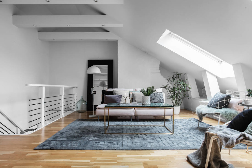 Inspiration for a scandinavian living room in Stockholm with white walls, light hardwood floors and brown floor.