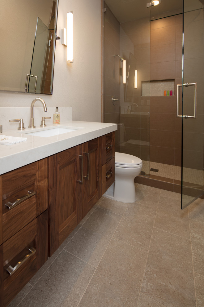 Inspiration for a mid-sized contemporary 3/4 bathroom in San Luis Obispo with recessed-panel cabinets, dark wood cabinets, an alcove shower, beige walls, porcelain floors, an undermount sink, quartzite benchtops, grey floor and a hinged shower door.