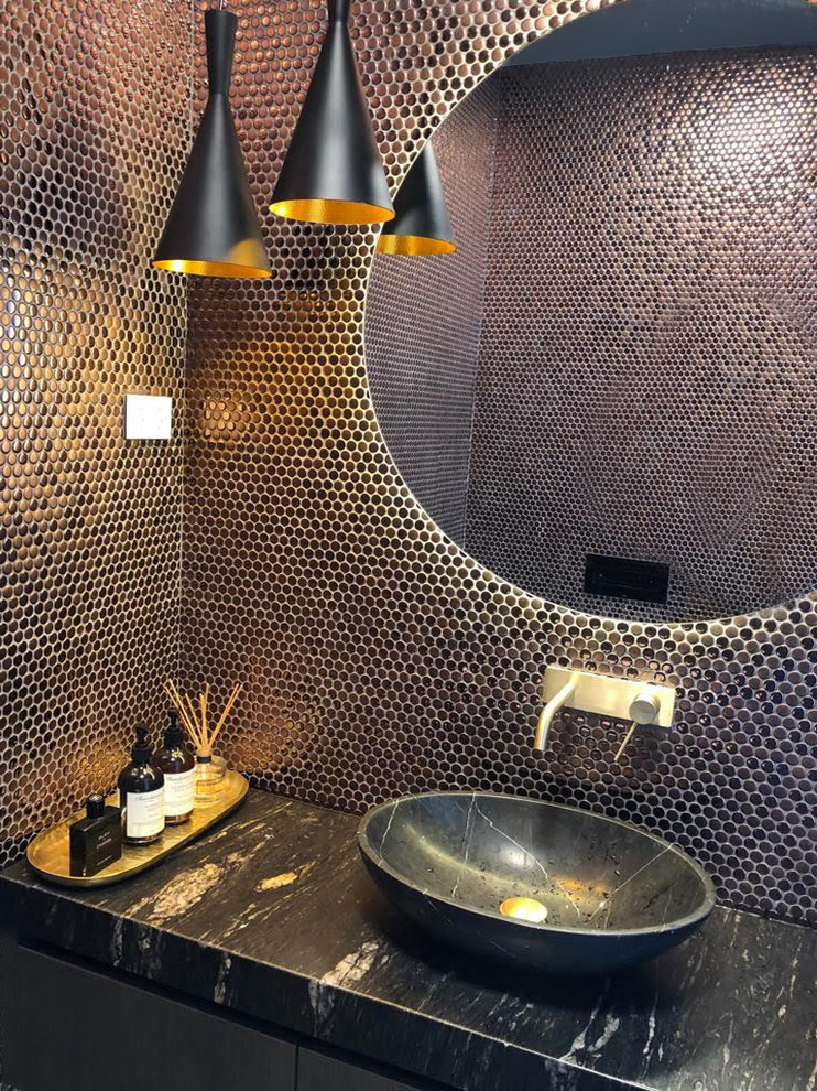 This is an example of a small contemporary powder room in Sydney with flat-panel cabinets, dark wood cabinets, mosaic tile, brown walls, a vessel sink, marble benchtops and black benchtops.