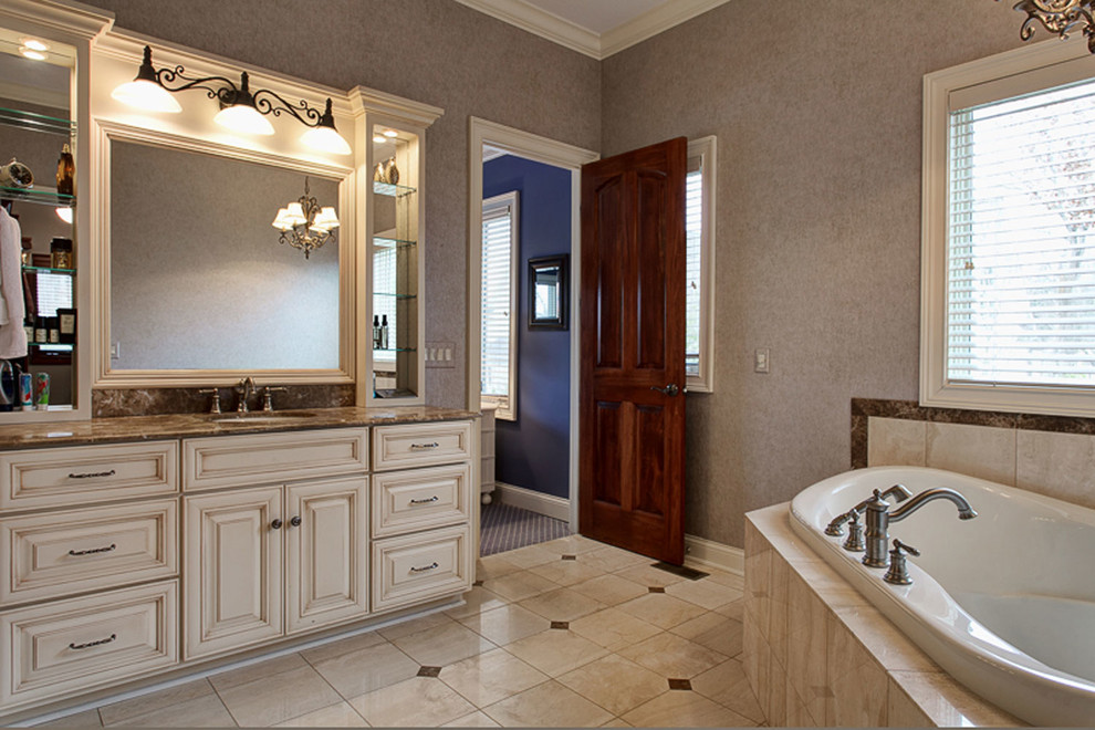 Large transitional bathroom in Columbus with an undermount sink, furniture-like cabinets, distressed cabinets, granite benchtops, a drop-in tub, an alcove shower, a one-piece toilet, beige tile, porcelain tile, grey walls and porcelain floors.
