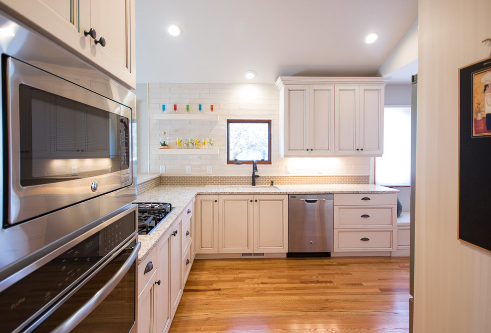 Mid-sized transitional light wood floor eat-in kitchen photo with an undermount sink, shaker cabinets, white cabinets, quartz countertops, white backsplash, ceramic backsplash and stainless steel appliances