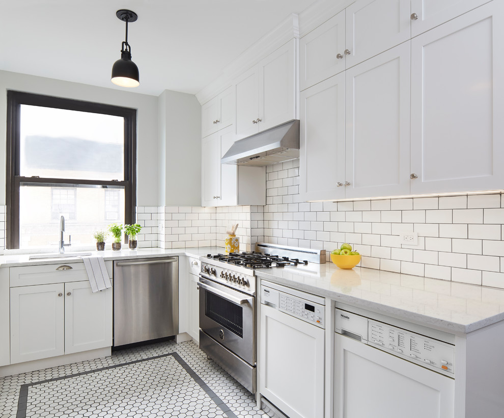This is an example of a mid-sized transitional kitchen in New York with an undermount sink, shaker cabinets, white cabinets, quartz benchtops, white splashback, subway tile splashback, stainless steel appliances, porcelain floors, no island, white benchtop and multi-coloured floor.