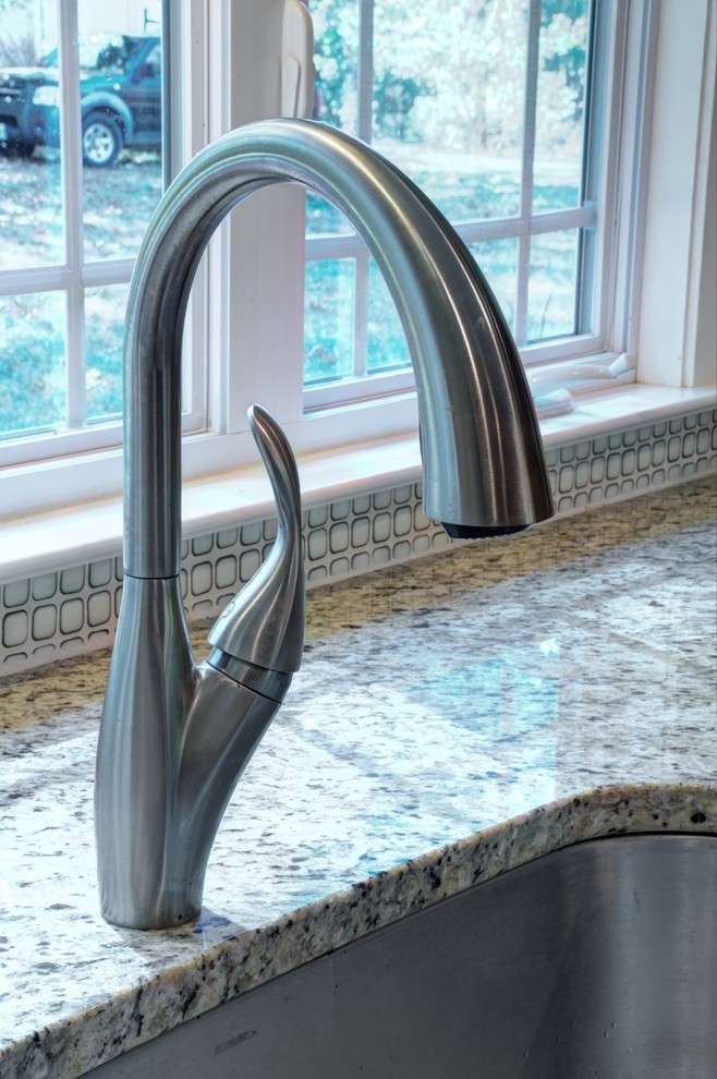 Example of a large transitional single-wall medium tone wood floor home design design in Baltimore with an undermount sink, recessed-panel cabinets, yellow cabinets, granite countertops, beige backsplash, ceramic backsplash, stainless steel appliances and an island