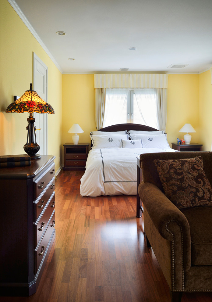 Design ideas for a mid-sized traditional master bedroom in Tokyo Suburbs with yellow walls, dark hardwood floors and brown floor.
