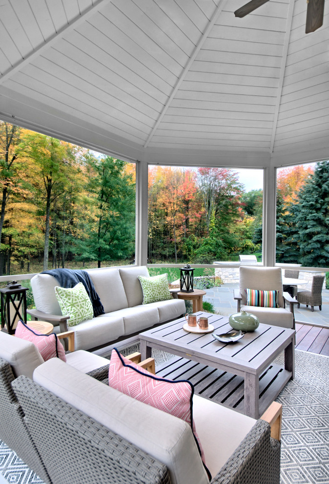 Idée de décoration pour un porche d'entrée de maison arrière tradition de taille moyenne avec une moustiquaire, une terrasse en bois et une extension de toiture.