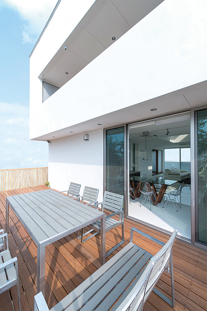Cette image montre une grande terrasse arrière et au premier étage minimaliste.