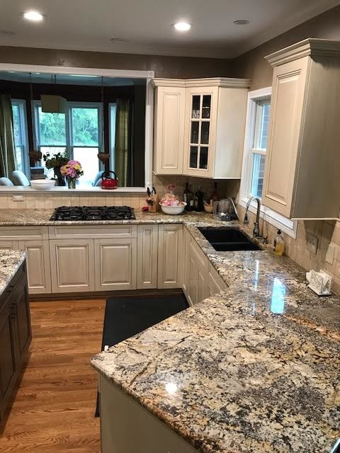 Design ideas for a large traditional u-shaped eat-in kitchen in Cincinnati with a double-bowl sink, shaker cabinets, beige cabinets, granite benchtops, beige splashback, travertine splashback, stainless steel appliances, medium hardwood floors, with island and brown floor.
